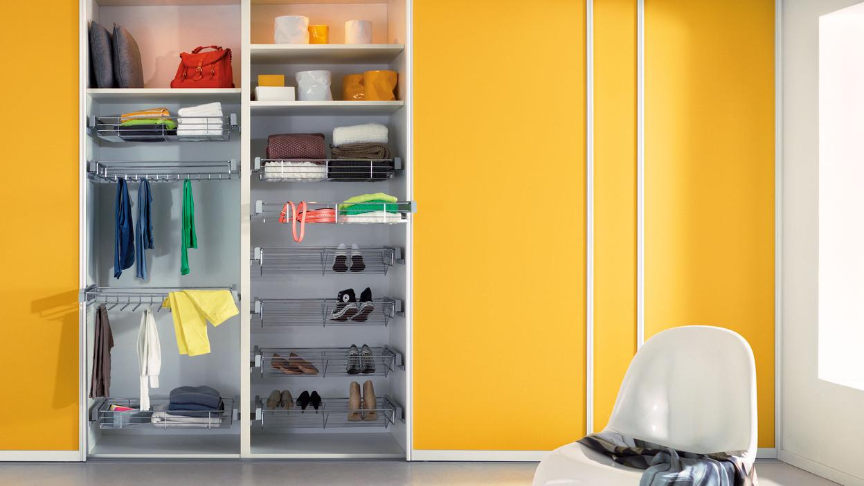 Einbauschrank mit gelben Türen und Metallkörben Einbauschrank mit gelben Türen und Metallkörben